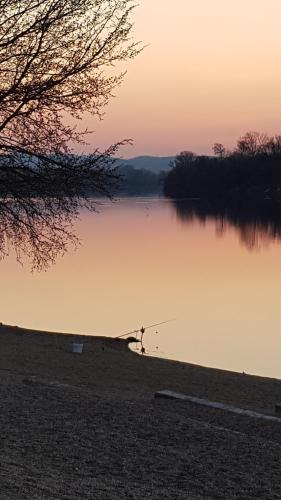 a view of a lake at sunset at Apartman Plaža Lux in Veliko Gradište