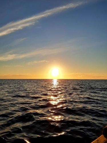 a sunset over the ocean with the sun setting at Cabañas Te Maori in Hanga Roa