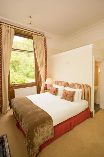 a bedroom with a large bed and a window at Springkell in Eaglesfield