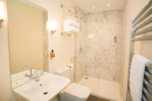 a bathroom with a sink and a toilet and a shower at Springkell in Eaglesfield