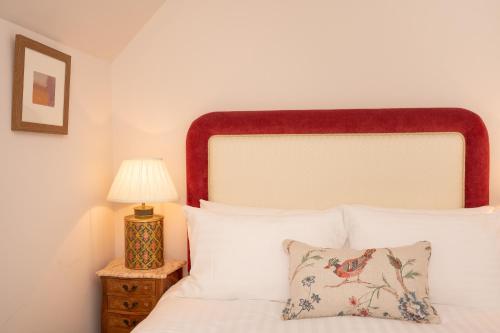 a bedroom with a white bed and a lamp at Springkell in Eaglesfield