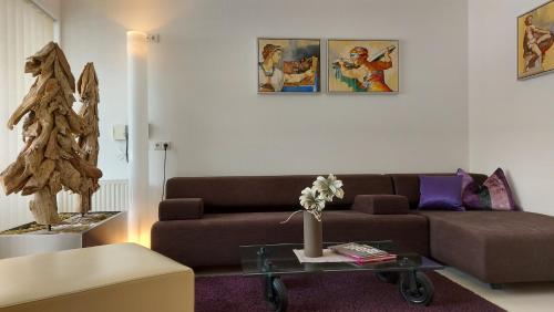 a living room with a brown couch and a table at Royal Appartements Sölden in Sölden