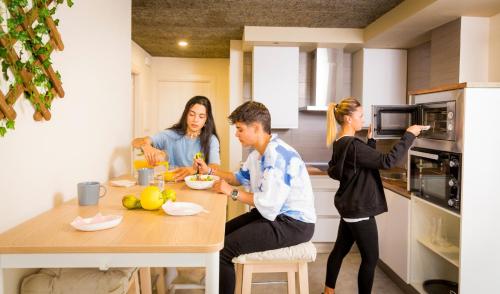 a group of people sitting at a table in a kitchen at Et Suseia in Muxia