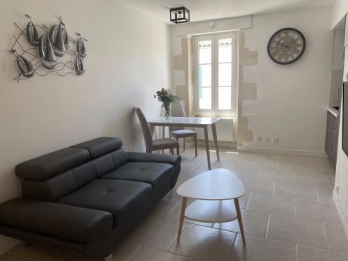 un salon avec un canapé et une table dans l'établissement Tribord, à La Flotte