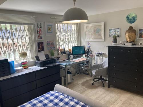 an office with a desk with a computer and a bed at STUNNING GROUND FLOOR GARDEN APARTMENT - Entire Apartment, Centrally Located, With Free Off Road Parking By Flat & Wiffi, Beautifully Secluded, 3 mins From All Amenities in London