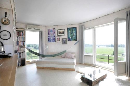 uma sala de estar com uma rede de descanso num quarto com janelas em Kullapesa em Kullamaa