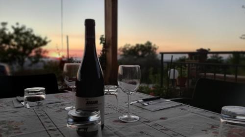 a bottle of wine sitting on a table with glasses at B&B CASA MARTINA in Giungano