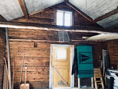 um quarto com uma parede de madeira e uma porta em Cosy river house em Kvillsfors