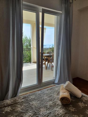 a bedroom with a door open to a balcony with a table at Villa Malena in Rab