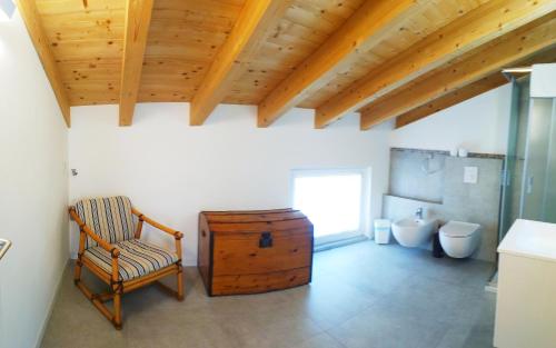 a bathroom with a chair and a wooden ceiling at sweet homes in Lecco