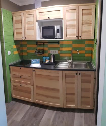 a small kitchen with a sink and a microwave at Apartments Helena Kranjska Gora in Kranjska Gora