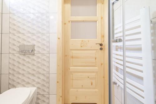 un bagno con porta in legno accanto alla doccia di Apartamenty Anna Maria-Chochołów a Chochołów