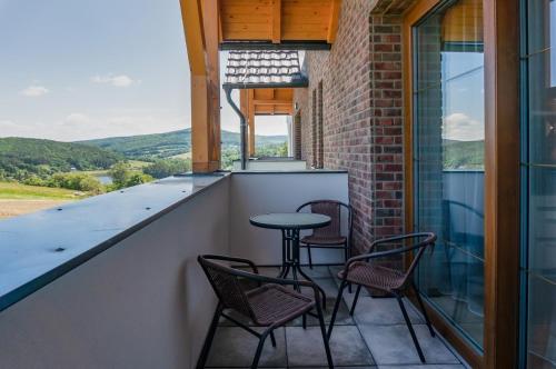 a patio with chairs and a table on a balcony at Wellness Apartmány Panorama in Luhačovice