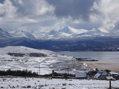 a snow covered mountain range with a town and a lake at Asgard in Big Sand