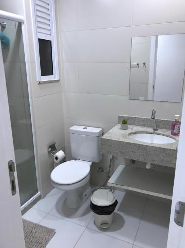 a white bathroom with a toilet and a sink at Apartamento, Apart Hotel, 02 Quartos - Arraial do Cabo in Arraial do Cabo