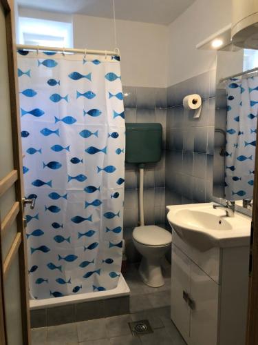a bathroom with a shower curtain with fishes on it at Apartment Vladka PARK in Izola