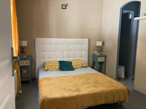 - une petite chambre avec un lit et 2 tables dans l'établissement Petite maison de campagne, à Bonifacio