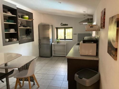 a kitchen with a refrigerator and a table and chairs at Petite maison de campagne in Bonifacio