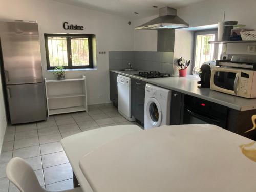 a kitchen with a washing machine and a microwave at Petite maison de campagne in Bonifacio