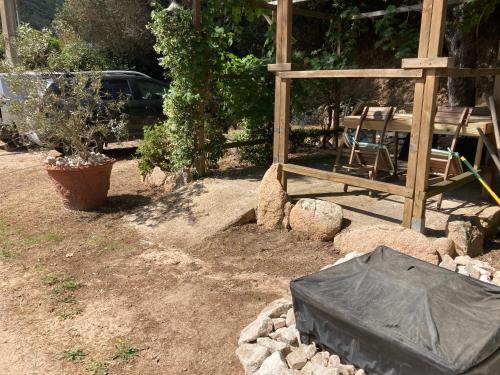 einen Garten mit einem Zaun, einem Tisch und einem Baum in der Unterkunft Petite maison de campagne in Bonifacio