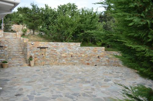 a stone retaining wall with a stone patio at Petrichor houses in Portariá