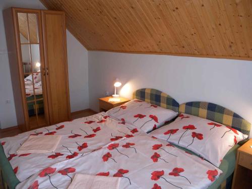 een slaapkamer met een bed met rode bloemen erop bij Apartment in Siofok/Balaton 35634 in Siófok