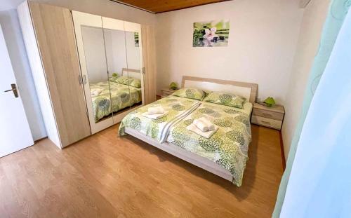 a small bedroom with a bed and a mirror at Apartment Kampor 4 in Kampor