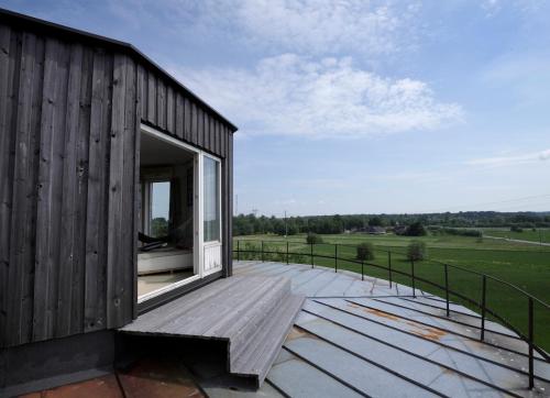 a house with a large window on a wooden deck at Kullapesa in Kullamaa