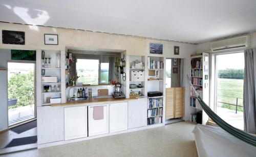 a kitchen with white cabinets and a large window at Kullapesa in Kullamaa