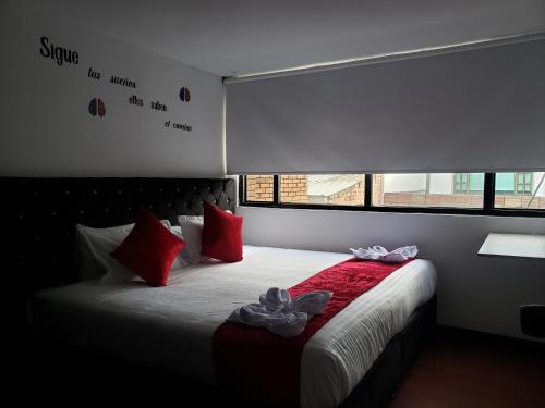 1 dormitorio con 1 cama con almohadas rojas en AW Hotel American Travel, en Bogotá