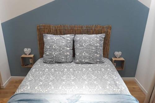 une chambre avec un lit avec deux oreillers dans l'établissement La Canisse 2 : joli appartement - Boulogne sur mer, à Boulogne-sur-Mer