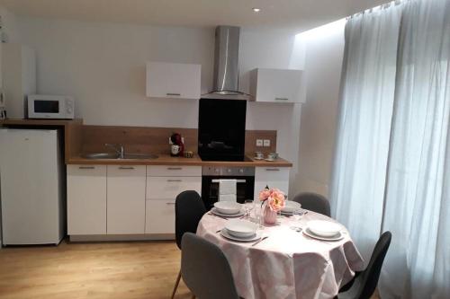 une cuisine avec une table et un chiffon de table blanc dans l'établissement La Canisse 2 : joli appartement - Boulogne sur mer, à Boulogne-sur-Mer