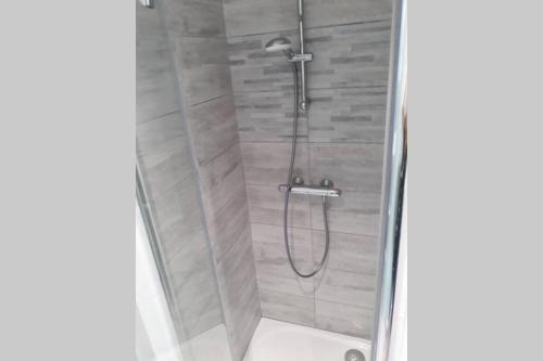 une douche avec une porte en verre et un constructeur de douche dans l'établissement La Canisse 2 : joli appartement - Boulogne sur mer, à Boulogne-sur-Mer