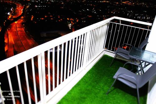 a balcony with two chairs and a table on the grass at MLH Premier Suites @ Saville Cheras in Cheras