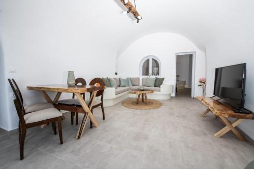 a living room with a couch and a tv at Sun Angelos Oia - Luxury Cave Suites in Oia