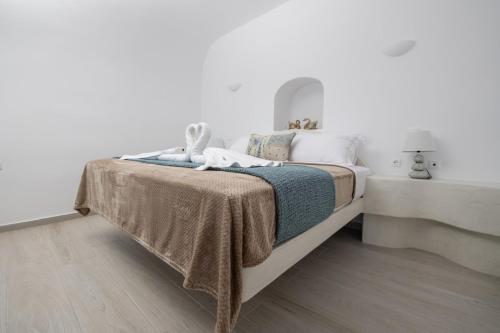 a bedroom with a bed with a blanket on it at Sun Angelos Oia - Luxury Cave Suites in Oia