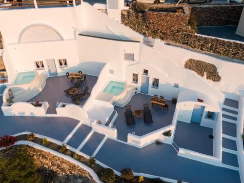 an overhead view of a white house with a pool at Sun Angelos Oia - Luxury Cave Suites in Oia