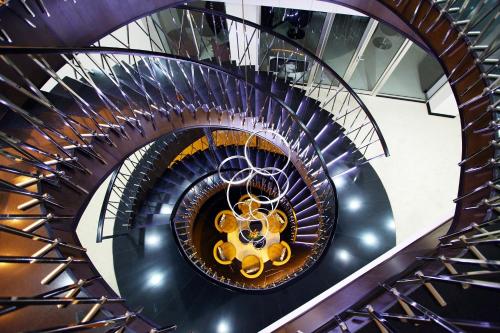 a spiral staircase in a building with a gold railing at North Avenue by Stellar Hotels, Yerevan in Yerevan