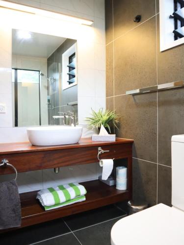 ein Bad mit einem Waschbecken und einem Spiegel in der Unterkunft Abera's Aitutaki Villas in Arutanga