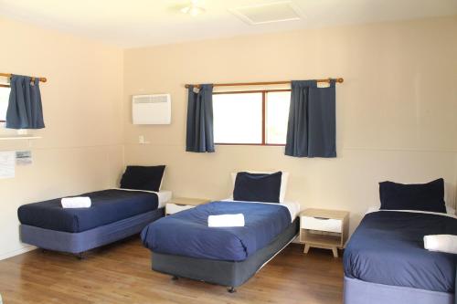 a room with two beds and a couch at The Barn Cabins & Camp in Marahau