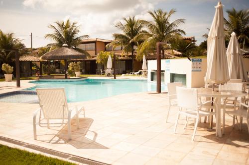 - Piscina con sillas, mesa y sombrillas en Geribá Beach Apart Hotel apt504, en Búzios