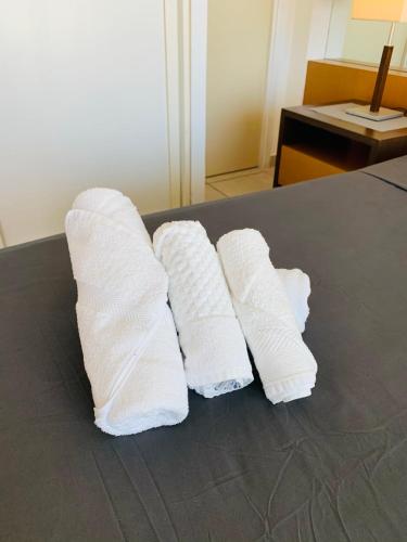 three rolls of white towels sitting on a table at Maravilhoso flat com vista para o Mar de Ponta Negra in Natal