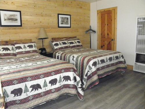 um quarto com 2 camas e uma parede de madeira em CREEKSIDE LODGE em Markleeville