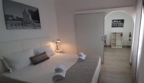 um quarto branco com uma cama e um candeeiro em Hostel de Borba - Just In House em Borba