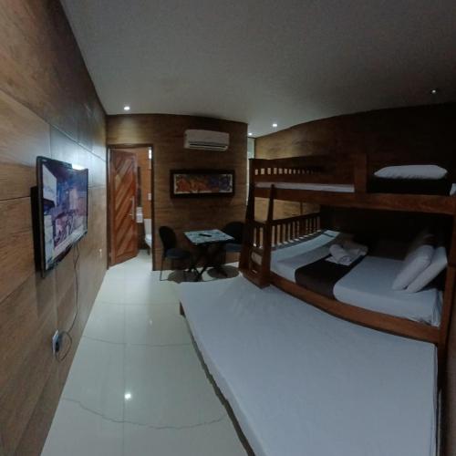 a room with two bunk beds and a flat screen tv at Recanto Convenções in Olinda