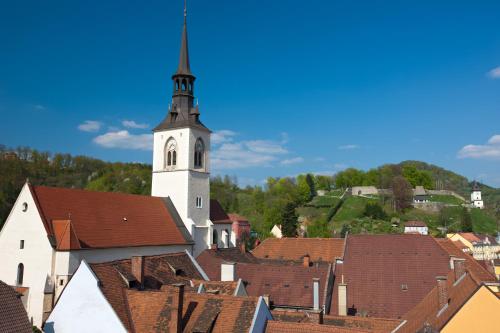 a church with a steeple on top of a town at Hotel Landskron in Bruck an der Mur