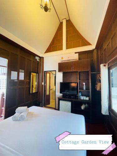 a bedroom with a white bed and a kitchen at Vimarn Samed Resort in Ko Samed