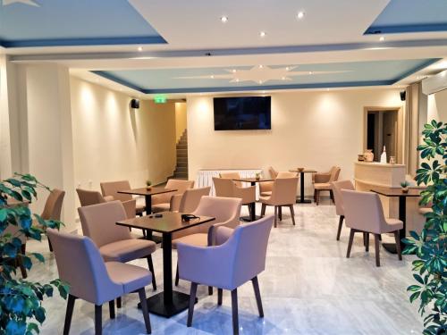 a restaurant with tables and chairs and a tv at Star Bay Luxury in Limenaria