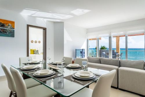 a dining room with a table and a couch at Mareazul Beach Front Condos At playa del Carmen in Playa del Carmen