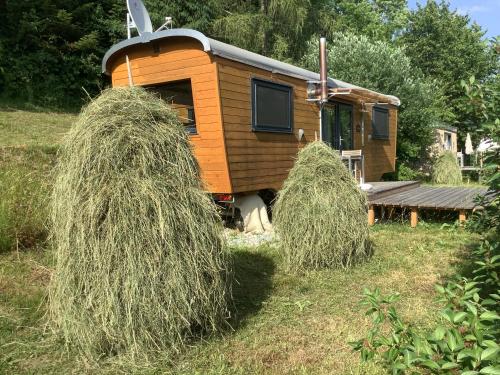 a tiny house with hay bales in the yard at Tiny House Steirerbua in Birkfeld